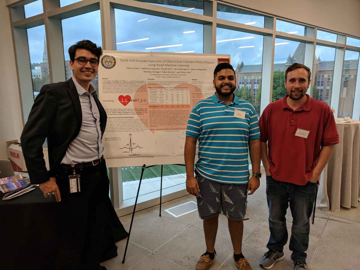 The HEARTio team standing beside their research poster at a conference